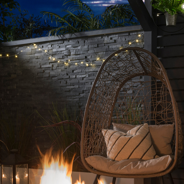 Split Face Black tiles decorated with string lighting and a hanging seat