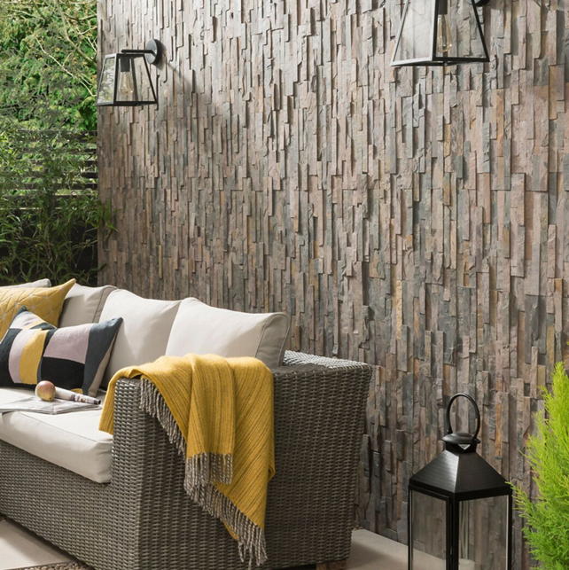 Split Face Dark Grey Tiles placed on a wall behind garden furniture